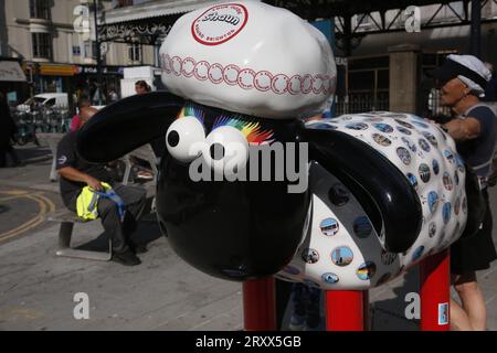 Brighton, Royaume-Uni. 27/septembre/2023 Norman Cook et Shaun le mouton sculptures à Brighton Norman Cook, alias Fatboy Slim, fait un demi-marathon à Brighton en visitant un certain nombre de sculptures Shaun le mouton spécialement décorées. La marche est sponsorisée et les statues ont été créées pour collecter des fonds pour l'Hospice Martlets dans la ville. À la gare de Brighton, Norman Cook rencontre l'artiste Sam Bailey avec son Shaun décoré intitulé « A round Brighton ». Crédit : Roland Ravenhill/Alamy. Banque D'Images