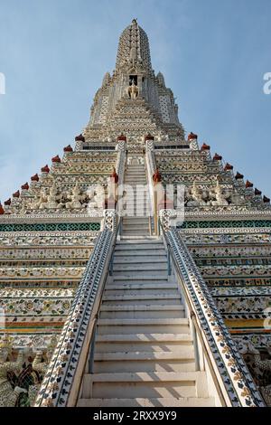 Un temple en Thaïlande avec une haute flèche ornée et un escalier menant à lui. La flèche est décorée de motifs et de motifs complexes. Banque D'Images