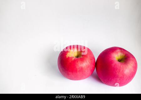 Deux pommes Fuji rouges sur fond isolé blanc Banque D'Images