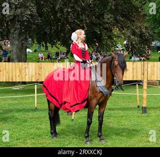 Dame en robe rouge à cheval prenant part en tant que reine à l'événement de joute, Lincoln Castle, Lincoln City, Lincolnshire, Angleterre, ROYAUME-UNI Banque D'Images