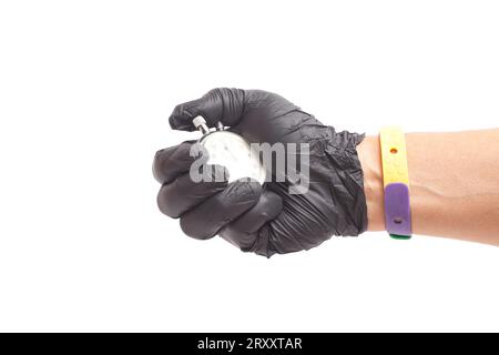 main dans des gants médicaux chirurgicaux noirs tient un chronomètre mécanique activé. Banque D'Images