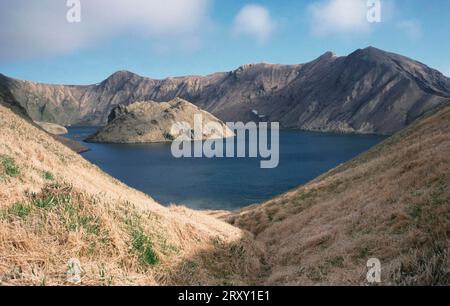 Vue d'une caldeira, cratère rempli d'eau de mer froide et d'eau de source chaude, île Yankicha, îles Kouriles, Russie Banque D'Images