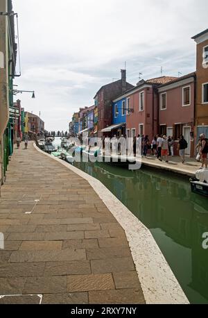 Burano, Vénétie, Italie, septembre 2023, scène de rue montrant des bateaux sur le canal et des maisons peintes colorées Banque D'Images