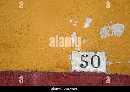 Numéro 50 sur un mur peint lumineux, photographié en gros plan au format paysage Banque D'Images