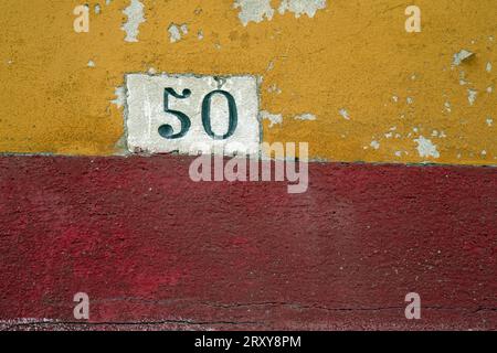 Numéro 50 sur un mur peint lumineux, photographié en gros plan au format paysage Banque D'Images