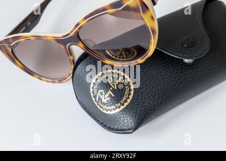 Londres. UK- 09.27.2023. Un étui à lunettes de soleil Ray Ban avec le logo de la marque de l'entreprise et une paire de lunettes de soleil isolées en blanc. Banque D'Images