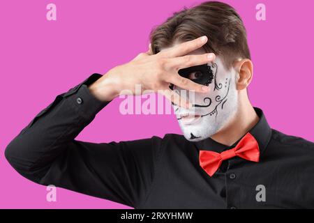 Jeune homme habillé pour Halloween sur fond de couleur, closeup Banque D'Images