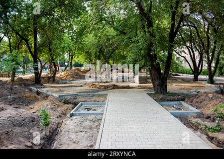 Travaux sur la pose d'un nouveau trottoir dans un parc municipal. Chemin constitué de dalles posées Banque D'Images