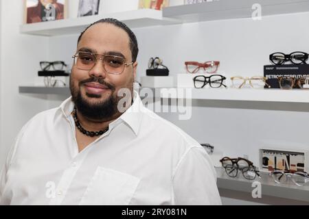 Paris, France. 27 septembre 2023. Le modèle Jeremy Bellet est conseillé sur son choix de lunettes par Alexandre Fontaine propriétaire du 'Watch Out! Boutique la lunette autrement, le 27 septembre 2023 à Paris, France. Crédit : Bernard Menigault/Alamy Live News Banque D'Images