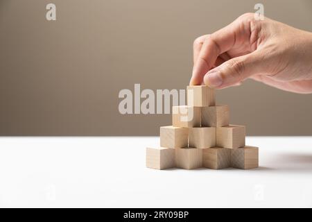 Les cubes de bois de mise à la main sont disposés dans une maquette en forme de pyramide Banque D'Images