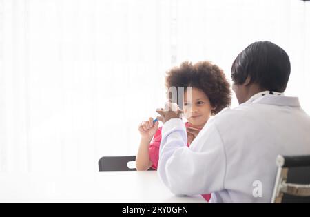 Dentiste afro-américain expliquant à un enfant afro métis comment se brosser les dents. Le médecin et le concept de santé de l'enfant. Banque D'Images