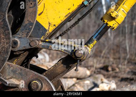 Gros plan des pièces métalliques usagées et bien usées du bras et du godet d'une vieille excavatrice. Banque D'Images