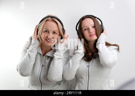 Mère et fille écoutant de la musique sur fond blanc. Photo de haute qualité Banque D'Images