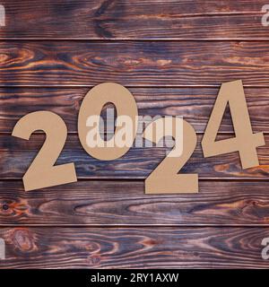 Numéros en carton 2024 Happy New Year Sign sur fond de table en bois. Rendu 3D. Banque D'Images