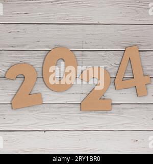 Numéros en carton 2024 Happy New Year Sign sur fond de table en bois. Rendu 3D. Banque D'Images