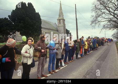 Protestation avec les armes liées. Aldermaston à Greenham Common vendredi Saint Pâques 1983. Les manifestants pour la paix formaient une chaîne humaine s'étendant sur 14 miles. Ils ont tracé une route le long de ce que les manifestants appellent la "Nuclear Valley" dans le Berkshire. La chaîne a commencé à la base aérienne américaine de Greenham Common, a dépassé le centre de recherche nucléaire d'Aldermaston et s'est terminée à l'usine de munitions de Burghfield. ANNÉES 1980 ROYAUME-UNI HOMER SYKES Banque D'Images