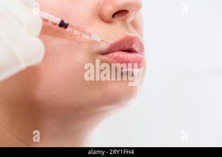 Gros plan de belle bouche et lèvres avec botox et seringue. Banque D'Images