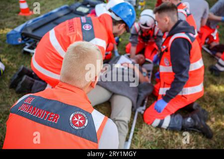 28 septembre 2023, Saxe, Wiederau : des ambulanciers paramédicaux d'urgence soignent un homme représentant une personne blessée lors d'un exercice de terreur. Environ 150 stagiaires de la Croix-Rouge allemande, des Samaritains et de l'Ambulance Saint-Jean de Saxe et de Saxe-Anhalt participent à une situation terroriste organisée à la fin d'une semaine d'entraînement. Il y a eu un assassinat avec de nombreuses victimes : l'auteur s'est retranché, des coups de feu sont tirés, il y a de la fumée, des policiers lourdement armés et cagoulés prennent d'assaut le bâtiment. Par la suite, les ambulanciers paramédicaux doivent soigner les blessés. Photo : Jan Woitas/dpa crédit : dpa pictur Banque D'Images