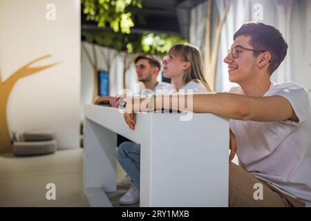 Étudiants à un concours de quiz avec mains sur un bouton Banque D'Images