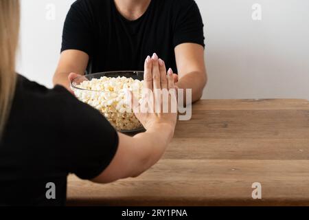 Femme déclinant Popcorn : éviter les graisses malsaines, les collations salées, snack Avoidance, régime cétogène, régime carnivore, régime pauvre en glucides, non-consommation de Co Banque D'Images