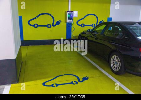 Voiture électrique en cours de recharge dans un parking souterrain Banque D'Images