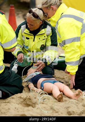 Une équipe d'ambulance pratique ses techniques de sauvetage sur un mannequin d'enfant au cours d'un exercice multi-agences pour tester l'intervention d'urgence, à Camber Sands, East Sussex. L'exercice multi-agences, organisé par le South East Coast Ambulance Service (SECAmb), inclut également la police du Sussex, le East Sussex Fire and Rescue Service, le Rother District Council, HM Coastguard et RNLI Lifeguards. Date de la photo : jeudi 28 septembre 2023. Banque D'Images