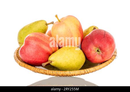 Plusieurs pommes rouges et poires vertes sur un plat en céramique, macro, isolées sur fond blanc. Banque D'Images