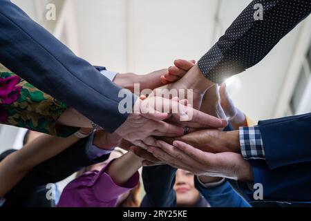 Concept d'équipe, de travail d'équipe et d'unité. Une équipe diversifiée qui met les mains ensemble. Groupe de gens d'affaires divers. Travailler ensemble en équipe. Partenariat Banque D'Images