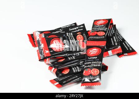 Pile de sachets d'assaisonnement ou sachet de Pizza Hut, une chaîne de restaurants américaine. ketchup ou sauce tomate avec petit emballage noir ou sachet. Banque D'Images