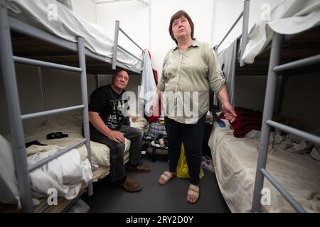 Berlin, Allemagne. 28 septembre 2023. Halina et Oleg d’Ukraine sont assis et debout entre leurs lits dans une chambre de 12 lits dans l’abri d’urgence pour réfugiés de l’ancien aéroport de Tegel. (À dpa 'combien viennent et restent? Chiffres de migration) crédit : Sebastian Gollnow/dpa/Alamy Live News Banque D'Images