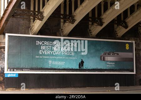 Publicité pour iPhone 15 Pro titane sur le réseau EE sous le pont ferroviaire victorien Deansgate, Manchester, Royaume-Uni. Banque D'Images