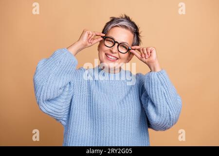 Photo d'une personne d'entreprise positive intelligente rayonnant des bras de sourire toucher des lunettes isolées sur fond de couleur beige Banque D'Images