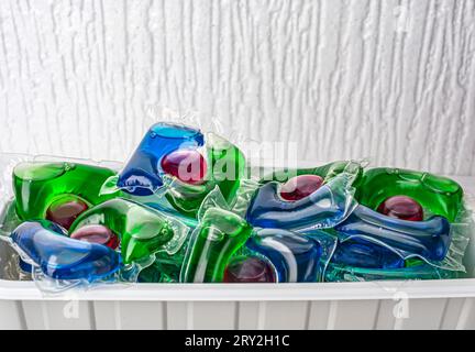 Capsules de blanchisserie et récipients en plastique isolés sur fond blanc. Photo de haute qualité Banque D'Images