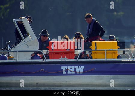 28 septembre 2023, Saxe-Anhalt, Arendsee : Sven Thomas (à droite), archéologue sous-marin de l'Office d'État de Saxe-Anhalt pour la préservation des monuments et de l'archéologie, se tient sur le lac Arendsee à bord d'un bateau THW à côté de ses collègues et surveille plusieurs moniteurs. Les archéologues enquêtent sur des sites au fond du lac Arendsee depuis le 25 septembre 2023. Au total, 20 cibles seront étudiées en haute résolution et en 3D d’ici la fin de la semaine. Entre autres choses, des clôtures à poissons de différentes époques ont été découvertes. L'Institut Fraunhofer d'Optronique, d'Ingénierie des systèmes et d'IMA Banque D'Images