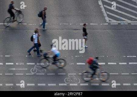 27 septembre 2023, Berlin : piétons et cyclistes se déplaçant sur un passage piétonnier et cyclable sur une route. (Effet d'essuyage dû à une longue exposition) photo : Sebastian Gollnow/dpa Banque D'Images