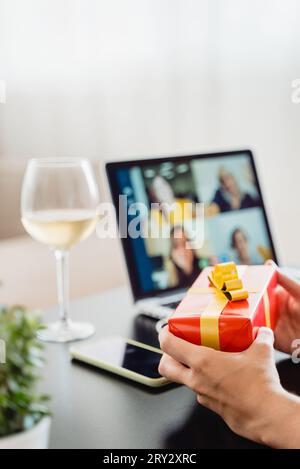 Famille et amis célébrant Noël sur la fête d'appel vidéo tout en tenant le cadeau à l'intérieur de la maison - vacances et tendance technologique Banque D'Images