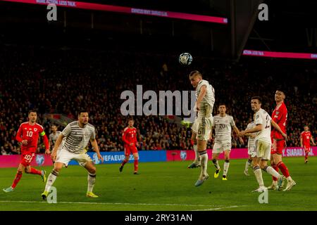 Cardiff, pays de Galles - 28 mars 2023 : le Letton Kristers Tobers grimpe haut et garde la balle au clair lors du Championnat d'Europe du Groupe D UEFA Qualifyin Banque D'Images