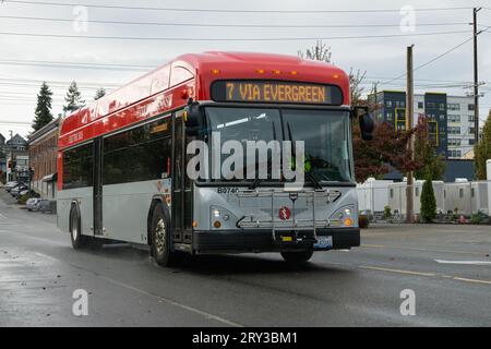 Everett, WA, États-Unis - 26 septembre 2023 ; Everett Transit autobus électrique dans la livrée rouge et grise sur la rue humide de la ville Banque D'Images