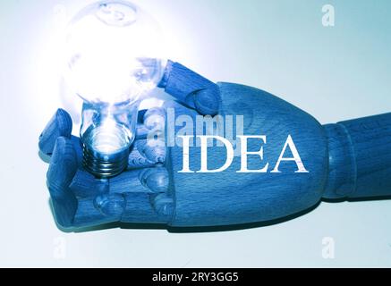 Main de robot avec tenue d'une ampoule de lampe avec le texte "idée" Banque D'Images