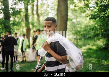 Portrait de garçon avec sac poubelle sur l'épaule Banque D'Images