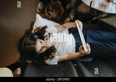 Vue à angle élevé de la fille à l'aide d'une tablette PC tout en voyageant dans le train Banque D'Images