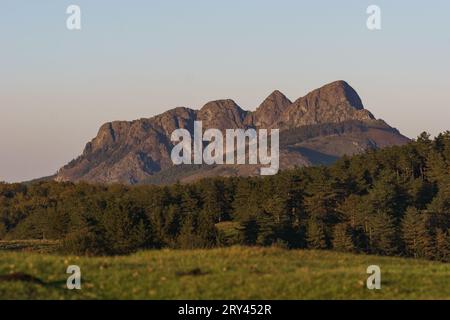 Paysage basque à l'heure dorée au coucher du soleil avec forêt et sommet de montagne Erroilbide formation rocheuse, Aiako Harria, Gipuzkoa, pays Basque, Espagne Banque D'Images