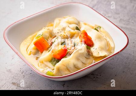 Gros plan d'un plat coréen appelé Mandu Guk. Soupe de type boulette remplie de viande. Banque D'Images