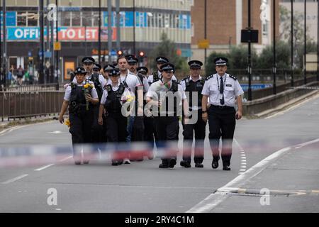 La police métropolitaine, y compris les premiers intervenants sur la scène de la mort poignardée de fleurs, où Elianne ANDAM, une élève de l'école privée Old Palace of John Whitgift, a été attaquée et tuée hier à 8h30 alors qu'elle descendait du bus à Croydon, South London, Croydon, London, Royaume-Uni 28 septembre 2023 crédit : Jeff Gilbert/Alamy Live News Banque D'Images