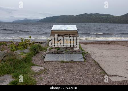 Ein steinernes Podest mit eine Informationstafel vor der Kulisse des Sees - Der Strand Dores Beach am Ostufer von Loch Ness in Schottland ist ein beliebter Spot für Wassersportler und Jäger von Nessie, dem Monster von Loch Ness. 28.09.2023 Dores Schottland Großbritannien *** Un piédestal en pierre avec un panneau d'information sur le fond du loch Dores Beach sur la rive est du Loch Ness en Écosse est un endroit populaire pour les amateurs de sports nautiques et les chasseurs de Nessie, The Loch Ness Monster 28 09 2023 Dores Scotland Royaume-Uni crédit : Imago/Alamy Live News Banque D'Images