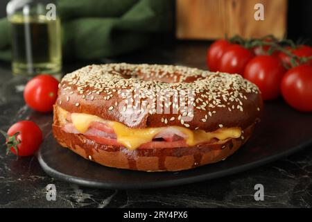 Délicieux bagel au jambon et au fromage sur une table en marbre foncé Banque D'Images