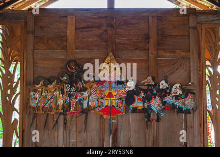 Wayang Kulit exposé sur un mur en bois. Marionnettes d'ombre traditionnelles indonésiennes et javanaises en cuir. Banque D'Images