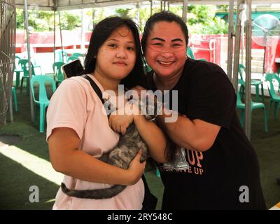 Navotas, Philippines. 28 septembre 2023. Deux dames posent pour une photo avec leur chat. Dans le cadre de la célébration de la Journée mondiale de la rage, le gouvernement de la ville de Navotas dirigé par le bureau de l'agriculture de la ville de Navotas, a procédé à la vaccination gratuite des chiens et des chats et à l'enregistrement des animaux de compagnie. Ils ont également donné gratuitement de la nourriture pour animaux de compagnie à ceux qui ont participé au programme. Crédit : SOPA Images Limited/Alamy Live News Banque D'Images