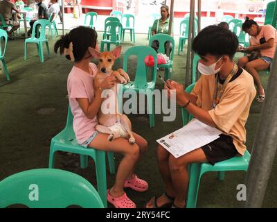 Navotas, Philippines. 28 septembre 2023. Un jeune couple a enregistré son chien pour la vaccination. Dans le cadre de la célébration de la Journée mondiale de la rage, le gouvernement de la ville de Navotas dirigé par le bureau de l'agriculture de la ville de Navotas, a procédé à la vaccination gratuite des chiens et des chats et à l'enregistrement des animaux de compagnie. Ils ont également donné gratuitement de la nourriture pour animaux de compagnie à ceux qui ont participé au programme. (Photo Josefiel Rivera/SOPA Images/Sipa USA) crédit : SIPA USA/Alamy Live News Banque D'Images