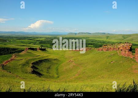 Vue du sommet de la montagne à un creux profond avec les restes d'un ancien sanctuaire en ruine construit en grès rouge. Coffres de la chaîne de montagnes, Khaka Banque D'Images
